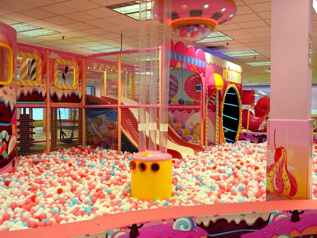 Pink and white candy-themed multi-level indoor playground with slides, climbing nets, tunnel towers and a giant ball pit at Star Park